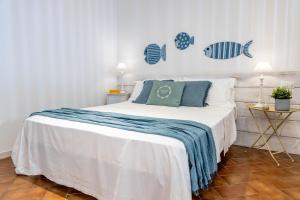 Un dormitorio con una cama blanca con almohadas azules. en Pascià Villagonia, en Taormina