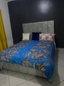 a bed with a blue comforter and pillows on it at Mila home in Arusha
