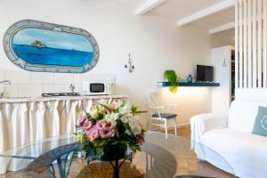 una sala de estar con una mesa de cristal con un jarrón de flores en Pascià Villagonia, en Taormina
