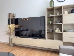 - un salon avec un grand centre de divertissement dans l'établissement Elite Business & Family Turnkey 433 Residence 2BR in OIA Motor City, à Dubaï