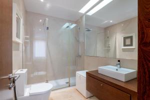 um banheiro com vaso sanitário, pia e chuveiro em The Povoa Villa na Póvoa do Varzim