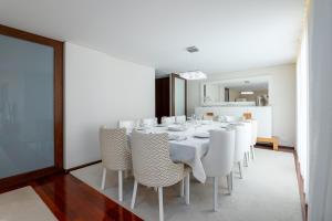 uma sala de jantar com uma mesa e cadeiras brancas em The Povoa Villa na Póvoa do Varzim mais 18 fotografias
