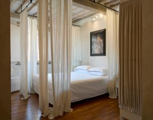 a bedroom with a bed with white drapes at Terrazza - A Bella Vista Apartment - Luxury in Lucca Centro in Lucca