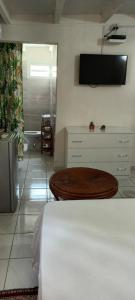 a room with a table and a tv on the wall at Chambre climatisée in Bouillante