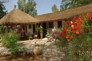 a small house with flowers in front of it at Bed and breakfast Keur Niaye in Toubakouta