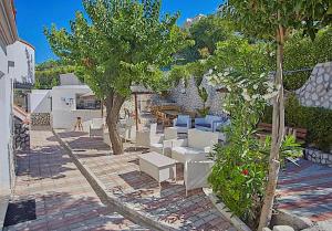 a group of white chairs and trees on a patio at Residence & Bed e Breakfast AlaMarina in Peschici