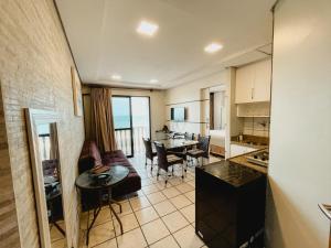 a kitchen and a living room with a couch and a table at Classic Residence in Fortaleza