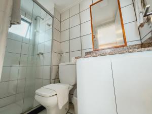 a bathroom with a toilet and a mirror at Classic Residence in Fortaleza
