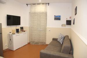 a living room with a couch and a television at La Casetta per te in Gravina di Catania