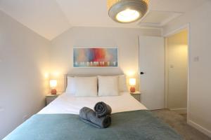 ein Schlafzimmer mit einem großen Bett mit zwei Kissen in der Unterkunft Wallaby - East Wittering Fisherman's Cottage in East Wittering