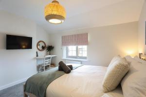 ein Schlafzimmer mit einem Bett und einem Fernseher darin in der Unterkunft Wallaby - East Wittering Fisherman's Cottage in East Wittering