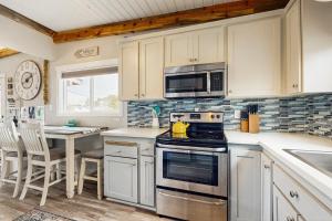 a kitchen with a stove and a microwave at The Sandbox at Rockaway Beach in Rockaway Beach +14 photos