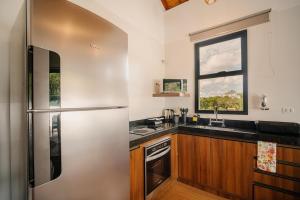 a kitchen with a stainless steel refrigerator and a window at Apartamento Le Neuf Centro in Monte Verde