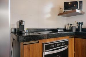a kitchen with a stove and a counter top at Apartamento Le Neuf Centro in Monte Verde