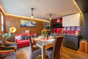 a kitchen and living room with a table and a red couch at Schnapskeller in Zermatt