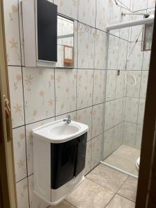 ein Badezimmer mit Waschbecken und Spiegel in der Unterkunft Cantinho da serra do Guaraú in Peruíbe + 32 Fotos