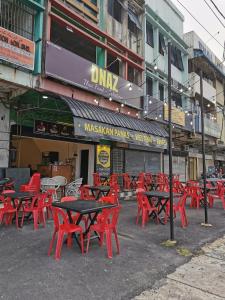 a group of red tables and chairs in front of a building at Hotel Bajet Gaya Warisan in Kota Bharu