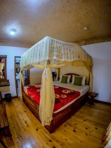 a bedroom with a large bed with a canopy at Mountain Range Cottage in Ella