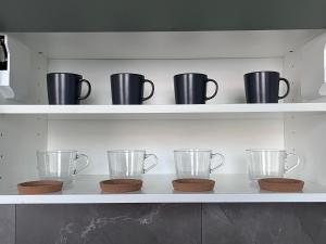a shelf with various pitchers and cups on it at Apartmán Pardubice in Pardubice