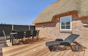 a deck with chairs and a table and a building at Stunning Home In Ulfborg With Sauna in Ulfborg +21 photos