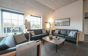 a living room with couches and a table and windows at Stunning Home In Ulfborg With Sauna in Ulfborg