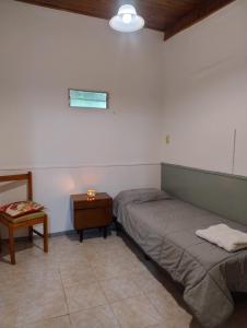 a bedroom with two beds and a night stand and a table at Alojamiento El Centenario in San Martín