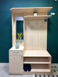 a wooden cabinet with a mirror in a room at Квартира-студия в центре Алматы in Almaty