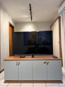 een grote flatscreen-tv bovenop een kast bij Loft moderno e aconchegante próximo ao Aeroporto, Rodoviária Interestatual, P Federal, Casv da Empaixada - Brasília in Brasilia