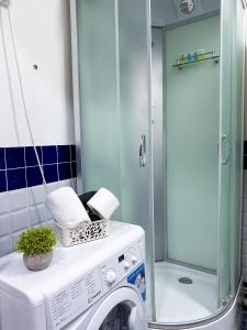 a washing machine in a bathroom with a shower at Квартира-студия в центре Алматы in Almaty +11 photos