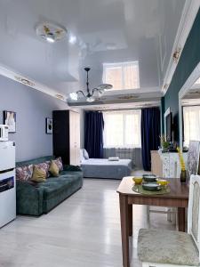 a living room with a couch and a table at Квартира-студия в центре Алматы in Almaty