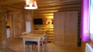 a dining room with a table in a log cabin at Appart Hôtel Le Pin Sylvestre in Amnéville