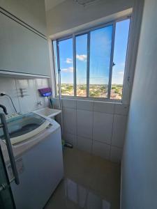 a small bathroom with a sink and a window at Apartamento Charmoso - Um Espaço de Harrison in Sarandi