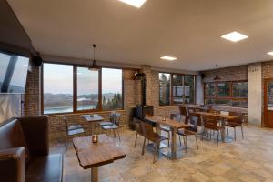 a restaurant with wooden tables and chairs and windows at Ktima Alonaki in Belokomiti