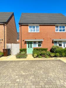 a red brick house with a green door at Lovely 2 bedroom home in Enham-Alamein
