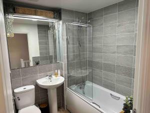 a bathroom with a toilet and a sink and a shower at Lovely 2 bedroom home in Enham-Alamein +16 photos