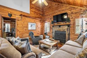a living room with a fireplace and a tv at Bear Hug Lodge in Ellijay