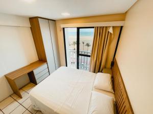 a bedroom with a bed and a large window at Classic Residence in Fortaleza