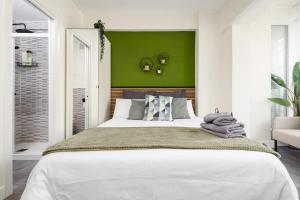 sypialnia z dużym łóżkiem i zieloną ścianą w obiekcie Beach Studio Apartment Playa Malagueta w Maladze