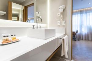 a white bathroom with a sink and a mirror at Hotel Astoria Ipanema in Rio de Janeiro +97 photos