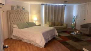 a bedroom with a large bed and a couch at Habitación Deluxe Acogedora Elsita in Santiago