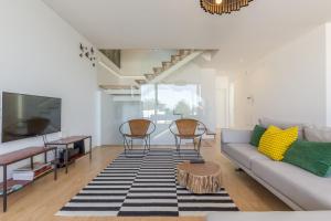 a living room with a couch and a table at Lemon Tree Home in Sesimbra