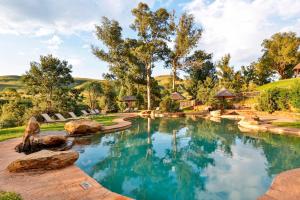 a swimming pool in a backyard with rocks in the water at Montusi Mountain Lodge in Bonjaneni