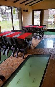 a row of tables in a room with red tables at House Of River in Moieciu de Sus