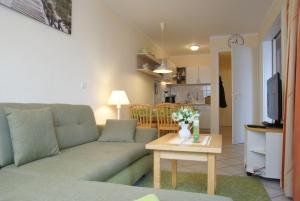uma sala de estar com um sofá e uma mesa em Seeparkpromenade Sellin Wohnung Morgensonne em Ostseebad Sellin