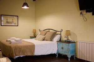 a bedroom with a large bed with a blue night stand at Loft El Roure, El Vilosell in El Vilosell