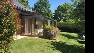 a glass house in a garden with a dog in it at Tajitu chambre table d hôte naturiste FKK in Chartres