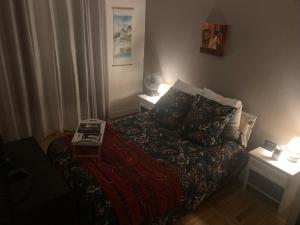 a small bedroom with a bed and two tables at Tajitu chambre table d hôte naturiste FKK in Chartres