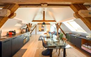cocina con techos de madera y mesa de cristal en Le passage des cinq - 5 min du tram 15 min Strasbourg centre, en Eckbolsheim