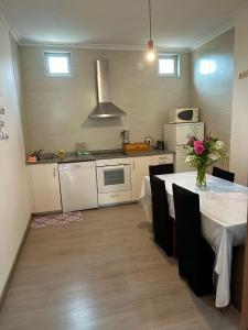 una cocina con una mesa con un jarrón de flores. en El Camino, en Laza