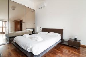 a bedroom with a large white bed with mirrors at Spacious Apartment 600 mt to Metro M3 Comasina in Milan